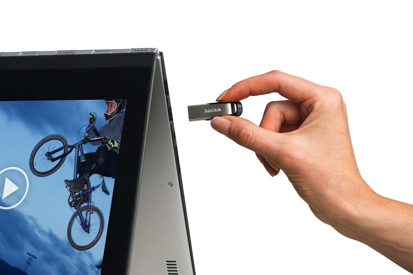 SanDisk Ultra Flair USB 3.0 flash drive being inserted into a laptop.